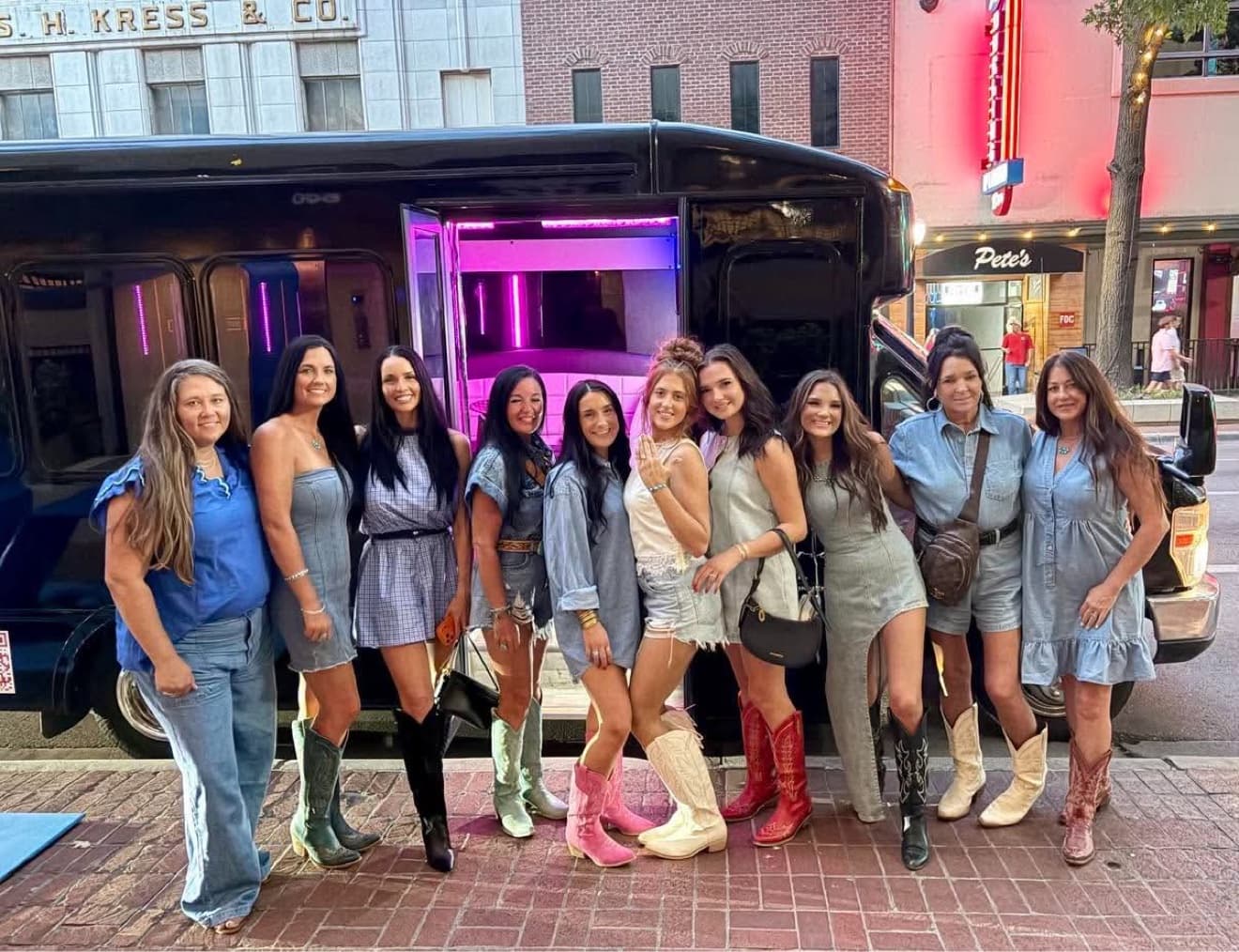 Bachelorette group in front of party bus with lights on
